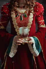 Wall Mural - Closeup on medieval queen in red dress with goblet