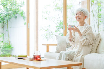 Wall Mural - リビングでお茶を飲むシニア女性