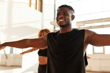 Wall Mural - sporty african american guy in sportswear does exercises and smiles in the gym, man goes in for sports