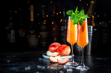 Wall Mural - Peach Bellini classic cocktail drink with sparkling wine and peach puree, syrup and ice, dark bar counter background