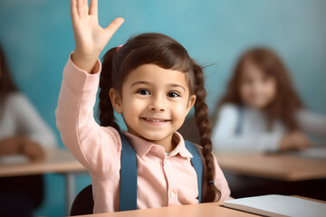 Wall Mural - Cute elementary school girl student raises her hand to answer the question on a class