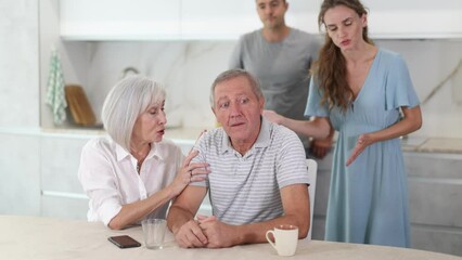 Wall Mural - Couple of adult years man and woman sit in kitchen and quarrel with children. High quality 4k footage