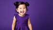 Happy Asian baby, smiling and laughing, wearing a solid purple dress. solid purple background similar to the dress color.