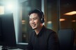 Portrait of a Handsome Asian Man, Customer Service Operator, Call Center Worker Talking Through Headset with Customer in Modern Office.