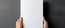 Mockup of a blank white journal being held displaying a softcover A4 book with clear magazine template With copyspace for text