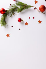 Canvas Print - Vertical image of stars, baubles decorations and fir tree branch with copy space on white background