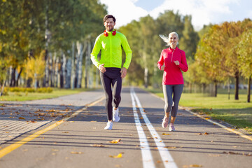  Running Sport Concepts. Positive Running Couple During Happily Jogging Outside as Runners Training Outdoors Working Out in City As Fitness Couple.
