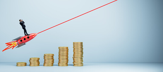 Poster - Young european businessman with binoculars standing on flying rocket, growing golden coin chart and mock up place on light wall. Start up, financial growth and success concept.