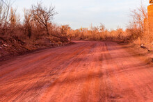 Red Dirt Road Polluted With The Iron Ore. Environmental Pollution
