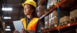 © The 2R Artificiality - Female worker in retail warehouse uses digital tablet and inventory checking software while wearing hard hat With copyspace for text