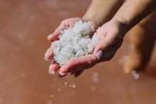 Hands of woman holding salt over lake water