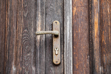 Sticker - Old wooden door. Closeup rusty door handle. Metal keyhole.