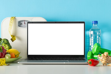 Wall Mural - Wellness-focused setup: side view of a table adorned with a scale, measuring tape, dumbbells, laptop, bowl of nuts, assorted fresh vegetables, set against a blue wall with ample space for text or ad