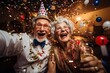 © Dina - Happy senior couple at New year party with confetti, laughing and smiling. Fun aging and cheerful retirement concept.
