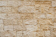 Ancient worn wall made of tuff bricks.