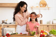 © Prostock-studio - Joyful mom and kid making salad having fun in kitchen