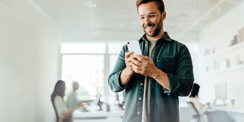 Poster - Business man reading a message on a mobile phone in an office