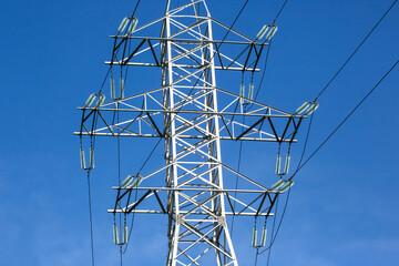 Wall Mural - Electrical tower with voltage transmission wires against the background of blue sky. High voltage tower. power line support with wires for electricity transmission. Energy industry.