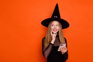 Sticker - Photo of tricky cunning lady wear black wizard costume cap typing halloween greetings looking empty space isolated orange color background