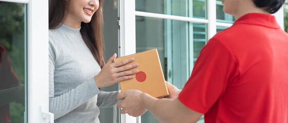 Wall Mural - Happy smiling woman receives boxes parcel from courier in front house. Delivery man send deliver express. online shopping, paper containers, takeaway, postman, delivery service, packages..