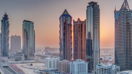 Wall Mural - Business bay district skyline with modern architecture timelapse during sunset from above. Aerial view of Dubai skyscrapers and towers near main highway. Traffic on a crossroad