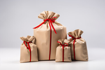 Christmas gift bags with red ribbons on a white background.