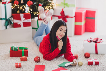 Photo of thoughtful pretty girl wear xmas red pullover writing congratulations letter indoors home room