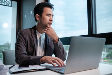 Businessman using laptop computer in office. Happy middle aged man, entrepreneur, small business owner working online.