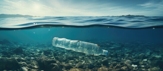 Wall Mural - dirty coast beach with plastic sea bottle floating with copyspace for text