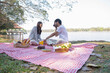 © MIND AND I - Couple having a picnic in a beautiful and natural park