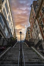 Low Angle Of A Staircase Between Residential Buildings In Montmartre, Paris, Frane At Sunset
