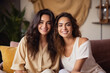 © Neha - Two Indian women best friends or sisters, sitting together at home.