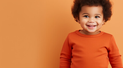 Wall Mural - Happy african-american child boy smiling to camera over orange background with copy space