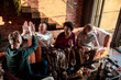 © Marko Geber - Diverse group of friends bonding over some wine and snacks in the living room at home