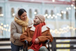 © Seventyfour - Portrait of young couple with man using wheelchair enjoying date outdoors in Christmas city, copy space