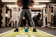 © Dusan Petkovic - Cropped picture of a dedicated sportswoman with kettle bell. Legs and hands on hips.