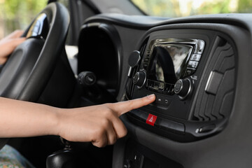 Wall Mural - Choosing favorite radio. Woman pressing button on vehicle audio in car, closeup