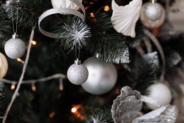 Sticker - Close up of beautiful fir branches with shiny golden, silver and white baubles or balls, xmas ornaments and garland lights,Christmas holidays background. Decoration on xmas tree.Festive new 2024 year.