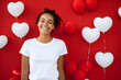Young woman wearing bella canvas white shirt mockup, red background with hearts balloons. Valentines day design tshirt template, print presentation mock-up.