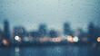 A softly raining scene against a blurred city backdrop raindrops streaking down. 