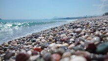 Close-up Of Sea Stones, On The Background Of Sea Surf. Sea Shore With Pebbles.