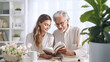 grandfather with his adult granddaughter reading a book 