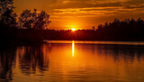 Fototapeta Zachód słońca - Vibrant orange sunset reflects on tranquil water, nature beauty showcased generated by AI