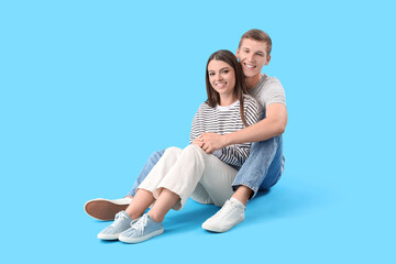 Poster - Happy young couple hugging on blue background