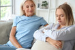 © Pixel-Shot - Happy young beautiful woman with her mother sitting in living room and spending time together