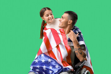 Wall Mural - Soldier in wheelchair with USA flag and his little daughter on green background. Veterans Day celebration