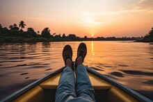 Close Up Of Man's Feet In Boat On The River At Sunset, Crop Unrecognizable Barefooted Male Traveler Sitting On Edge Of Boat During Cruise On Rippling Nile River Against Cloudless, AI Generated