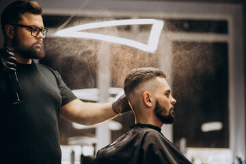 Handsome man at a barber shop making hair style