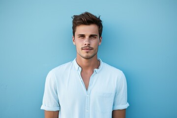 Attractive young man face on blue wall. Looking fashion person with big blue eyes. Generate Ai