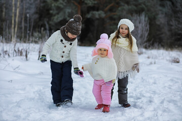 Wall Mural - Happy family playing and laughing in winter outdoors in the snow. City park winter day.